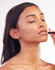 Image showing Beauty, makeup and pencil on face of woman in studio for cosmetics, lip liner and product. Salon, self care and glow with female model on white background for application, lipstick and facial