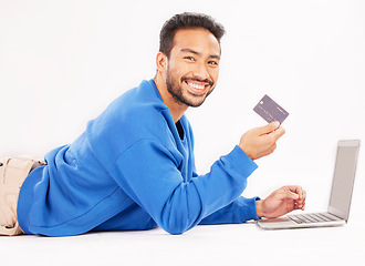 Image showing Online shopping, laptop and portrait man smile for credit card discount, fintech service or ecommerce sale. Studio customer, savings transfer payment or relax person banking on white background floor