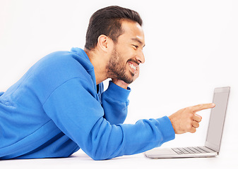 Image showing Smile, laptop and man pointing on studio floor isolated on a white background. Computer, happy or person on ground for social media, streaming movie or film, video or show on internet with technology