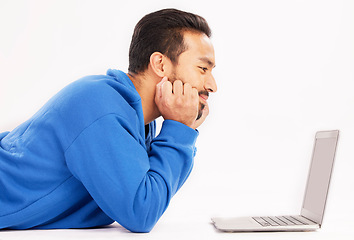 Image showing Man, laptop and relax on studio floor for digital streaming, online show and download subscription. Happy asian male model watch connection on computer technology, internet news and white background