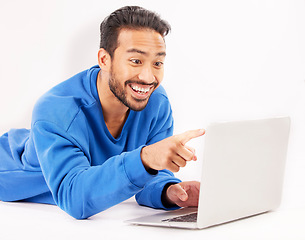 Image showing Surprise, laptop and man pointing on studio floor isolated on a white background. Computer, happy and person on ground for social media, streaming movie or film, video or show on internet with tech