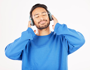 Image showing Asian man, headphones and music in studio, white background and relax while hearing podcast subscription. Happy male model listening to calm audio, streaming sound and radio media with technology