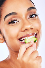 Image showing Portrait, cucumber and Indian woman in studio for health, diet and detox, nutrition or wellness. Fruit, slice and face of lady with natural, vegan or organic snack for weight loss, fiber or hydration