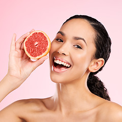 Image showing Grapefruit, beauty and face of happy woman with skin care, dermatology or natural glow. Portrait of a female model with fruit for vitamin c, cosmetics or healthy diet for detox on studio background