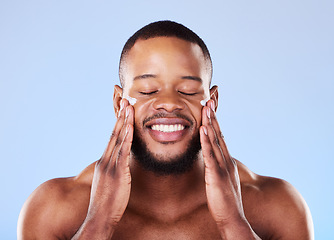 Image showing Beauty, skincare and cream on face of black man in studio for sunscreen, cosmetics and spa treatment. Facial, self care and dermatology with person on blue background for lotion, wellness and health