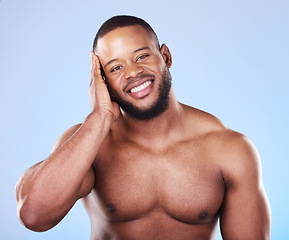 Image showing Happy, skincare and portrait of a black man with a glow on a blue background from dermatology. Smile, touching and an African person or model with facial wellness, health and cleaning for beauty