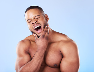 Image showing Tired, yawning and a black man with skincare on a blue background for beauty and wellness. Health, model and an African person or model with fatigue isolated on a studio backdrop for wellbeing