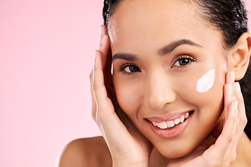 Image showing Cream, beauty and face of a woman with skin care, dermatology and natural glow. Closeup of a young female model with a smile for moisturizer, cosmetic space or sunscreen on pink background in studio