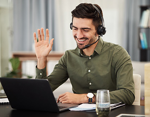 Image showing Man, remote work and virtual assistant with headphones at laptop for video call, voip communication and telemarketing. Consultant wave at computer with microphone for customer support at home office