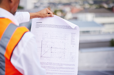 Image showing Construction site, blueprint and man reading document of building proposal in city from the back. Closeup design of floor plan, project or architecture for industrial development in civil engineering