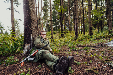 Image showing A terrorist on a break from warfare, resting during heavy war fare and attack