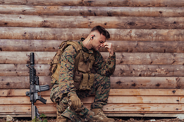 Image showing Upset soldier has psychological problems holding his head