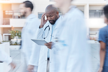 Image showing Tablet, doctor and black man with headache in busy hospital, fatigue or burnout. Tech, medical professional or person with problem, crisis or challenge, stress or anxiety in mistake, fail or disaster