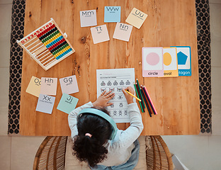 Image showing Above, child and girl writing on table for homework or remote learning in home for development, growth and education. Kid, working and studying for school, math and writing on paper in living room