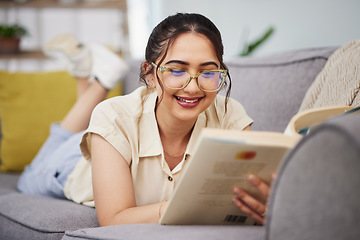 Image showing Happy woman, reading and book on sofa in home for story, novel and studying literature. Young student, gen z girl and relax with books in lounge for learning, knowledge and education in living room