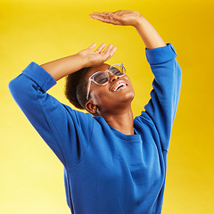 Image showing Fashion, freedom and fun with a black woman on a yellow background in studio for trendy gen z style. Relax, smile and excited with a happy young girl indoor to dance with a carefree expression