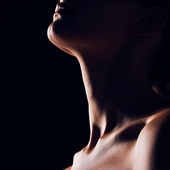 Image showing Skincare, neck and person on black background for creative lighting, shadow and silhouette. Aesthetic, beauty and closeup of body in dark studio with macro of skin for art deco, wellness and glow