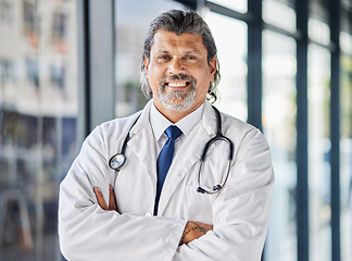Image showing Portrait, man and doctor with arms crossed, smile and surgeon with confidence, career and medicine. Face, mature person and medical professional in a hospital, healthcare expert and happy employee