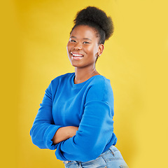 Image showing Portrait, smile and arms crossed with a black woman on a yellow background in studio for fashion. Happy, confident and proud with a happy young person posing for trendy style in a clothes outfit