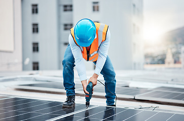 Image showing Engineer man, drill and solar panel on roof with industry, sustainability or construction in city. Technician, power tools and photovoltaic system for building, development or renewable energy in cbd