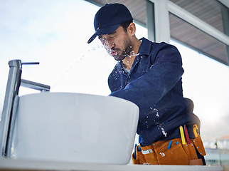 Image showing Plumbing, fail and asian man in bathroom with water splash, crisis or basin leak or accident in a house. Faucet, emergency and male plumber with mistake, problem and pipe flood in home repairs