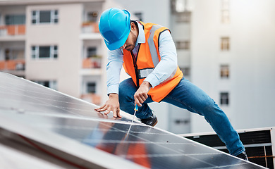 Image showing Technician man, screwdriver and solar panel on roof for maintenance, industry and construction in city. Engineer, tools and photovoltaic system for building, development and renewable energy in cbd