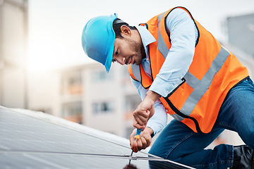 Image showing Solar panels, tool and male engineer on a rooftop doing maintenance or repairs with screwdriver. Renovation, handyman and zoom of an industrial worker working on eco friendly construction on building