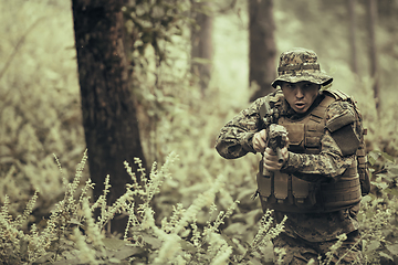 Image showing A modern warfare soldier on war duty in dense and dangerous forest areas. Dangerous military rescue operations