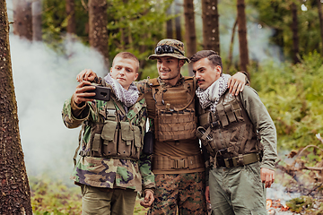 Image showing Team of soldiers and terrorist taking selfie with smartphone in the forest