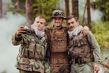 Image showing Team of soldiers and terrorist taking selfie with smartphone in the forest