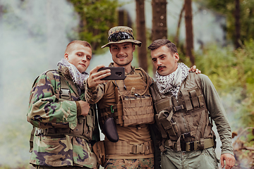 Image showing Team of soldiers and terrorist taking selfie with smartphone in the forest