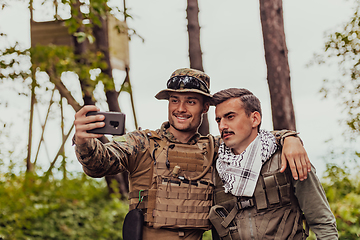 Image showing Team of soldiers and terrorist taking selfie with smartphone in the forest