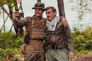 Image showing Team of soldiers and terrorist taking selfie with smartphone in the forest