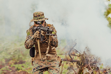 Image showing A soldier fights in a warforest area surrounded by fire