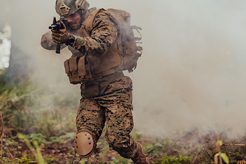 Image showing A soldier fights in a warforest area surrounded by fire