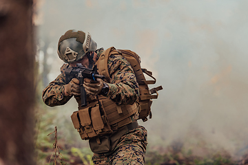 Image showing A soldier fights in a warforest area surrounded by fire