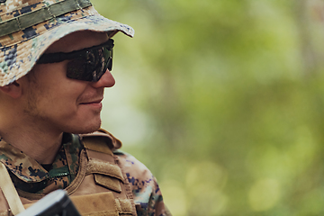 Image showing Soldier portrait with protective army tactical gear and weapon having a break and relaxing