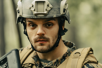 Image showing Soldier portrait with protective army tactical gear and weapon having a break and relaxing