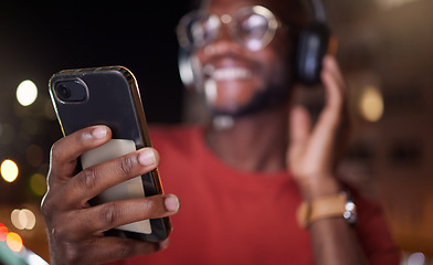 Image showing Man hands, phone and music in a city at night with online streaming and audio. Podcast, web radio and internet broadcast with a African male person smile and mobile networking feeling happy with text