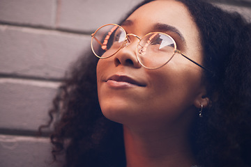 Image showing .Face, thinking and glasses with a black woman in the city at night against a brick wall closeup for vision. Idea, happy and eyewear with a young female person looking to the future while outdoor.