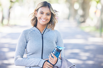 Image showing Nature, fitness and portrait of a woman with a water bottle for an outdoor workout or training. Sports, happy and young female athlete with a smile in a park for a running cardio exercise in a garden