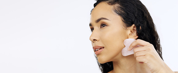 Image showing Black woman, face and beauty with gua sha for skincare, facial and exfoliate isolated on white background. Dermatology, skin glow and cosmetic tools, female model satisfied with hand and mockup