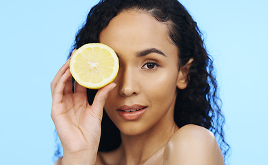 Image showing Lemon, face skincare and beauty of woman in studio, vegan wellness or blue background. Model, portrait and citrus fruits for facial cosmetics, vitamin c aesthetic or healthy natural detox dermatology