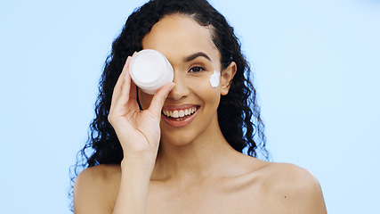 Image showing Face, cream jar and beauty of woman, cosmetics and smile on blue background. Facial lotion, skincare and portrait of happy studio model with container for shine, natural wellness and aesthetic makeup