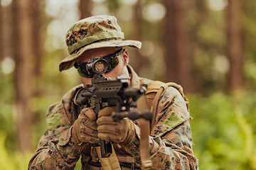 Image showing A modern warfare soldier on war duty in dense and dangerous forest areas. Dangerous military rescue operations