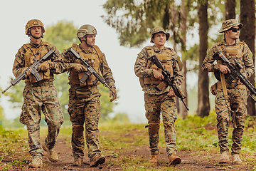 Image showing Soldier fighters standing together with guns. Group portrait of US army elite members, private military company servicemen, anti terrorist squad