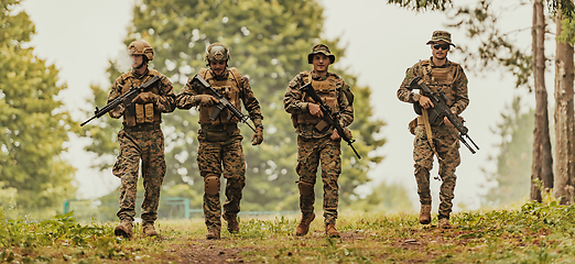 Image showing Soldier fighters standing together with guns. Group portrait of US army elite members, private military company servicemen, anti terrorist squad