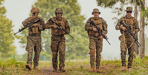 Image showing Soldier fighters standing together with guns. Group portrait of US army elite members, private military company servicemen, anti terrorist squad