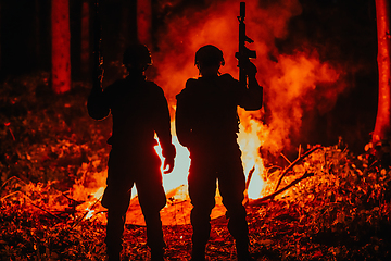 Image showing Special marines military forces squad soldiers group portrait after finished mission complete fire in background