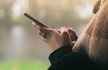 Image showing Hands, phone and social media with a person on a blurred background outdoor on an overcast day. Mobile, contact and communication with an adult typing a text message in the rain during winter